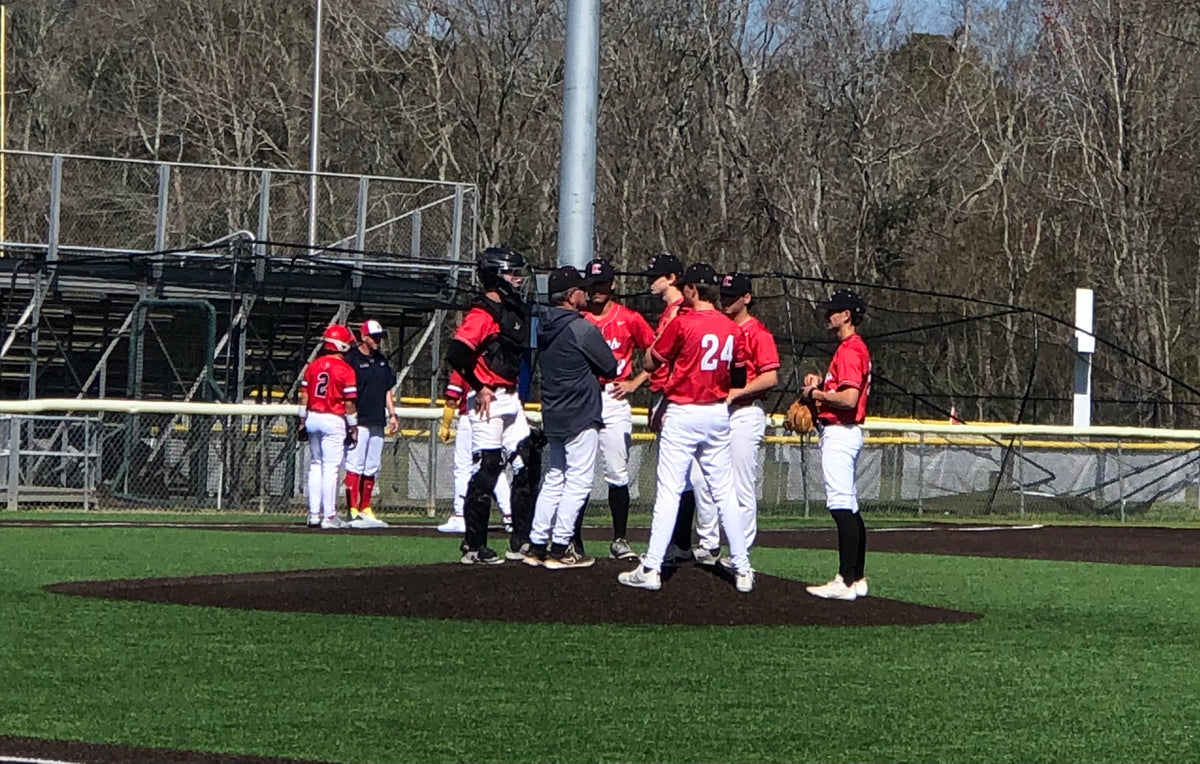 Baseball players on a field with a dugout in the background