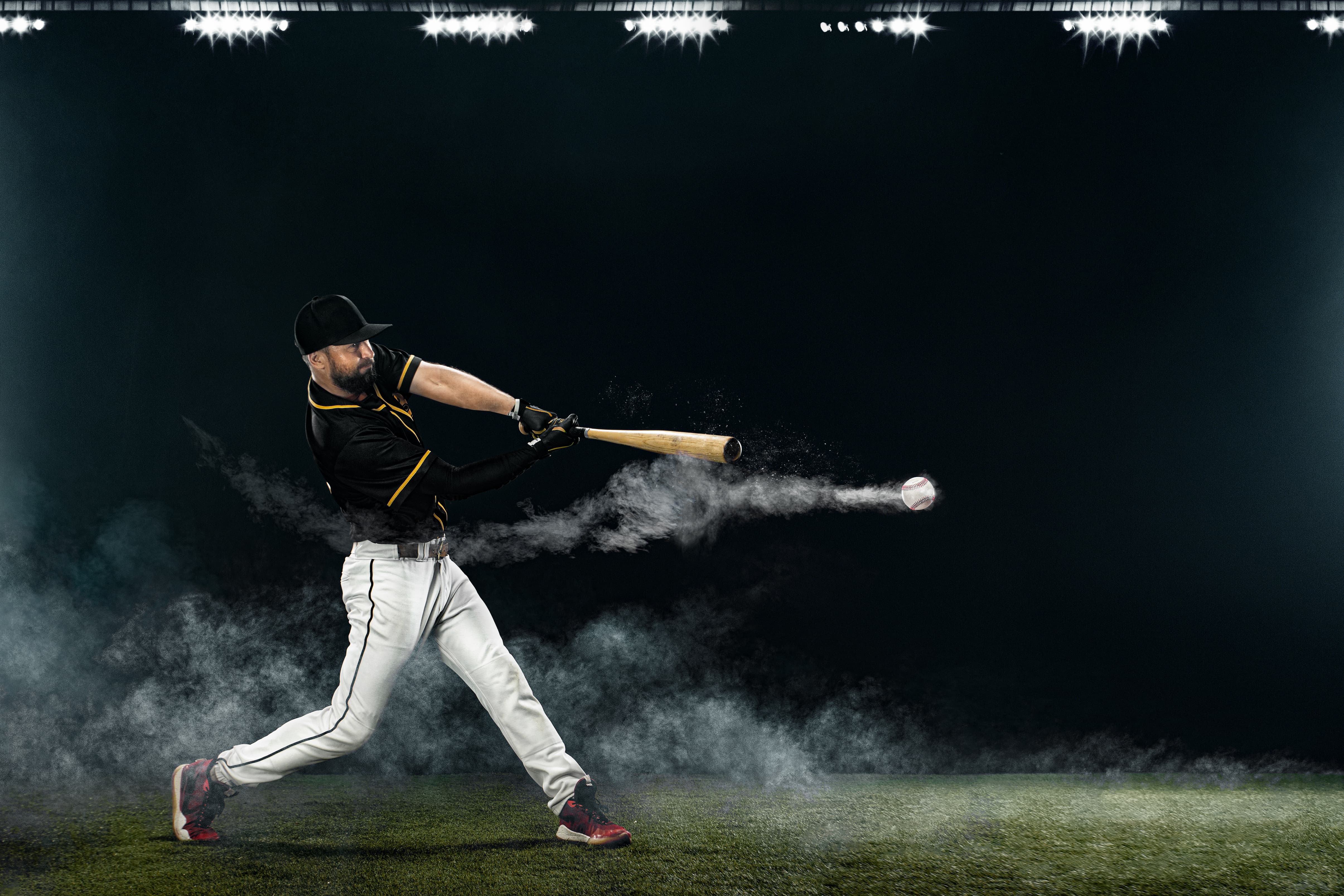 Baseball player in action on a dark field with smoke effects
